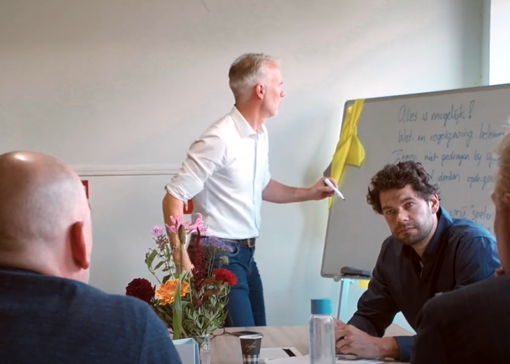 Man schrijft woorden op whiteboard tijdens kennistafelsessie