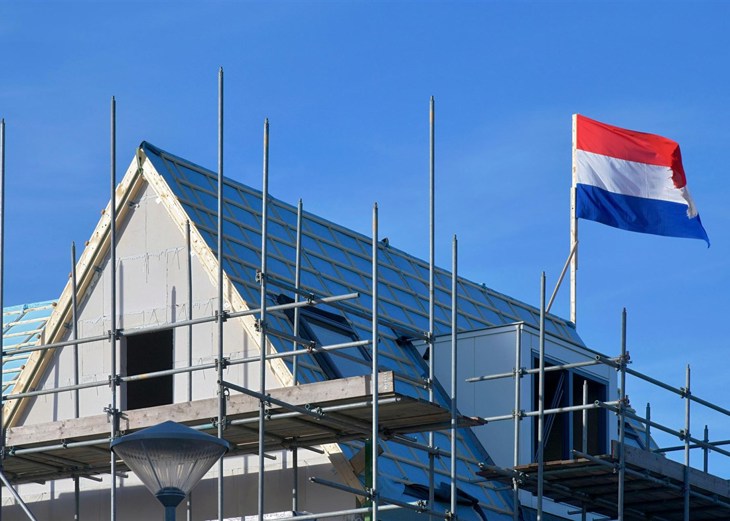 Dak van huis in aanbouw met Nederlandse vlag